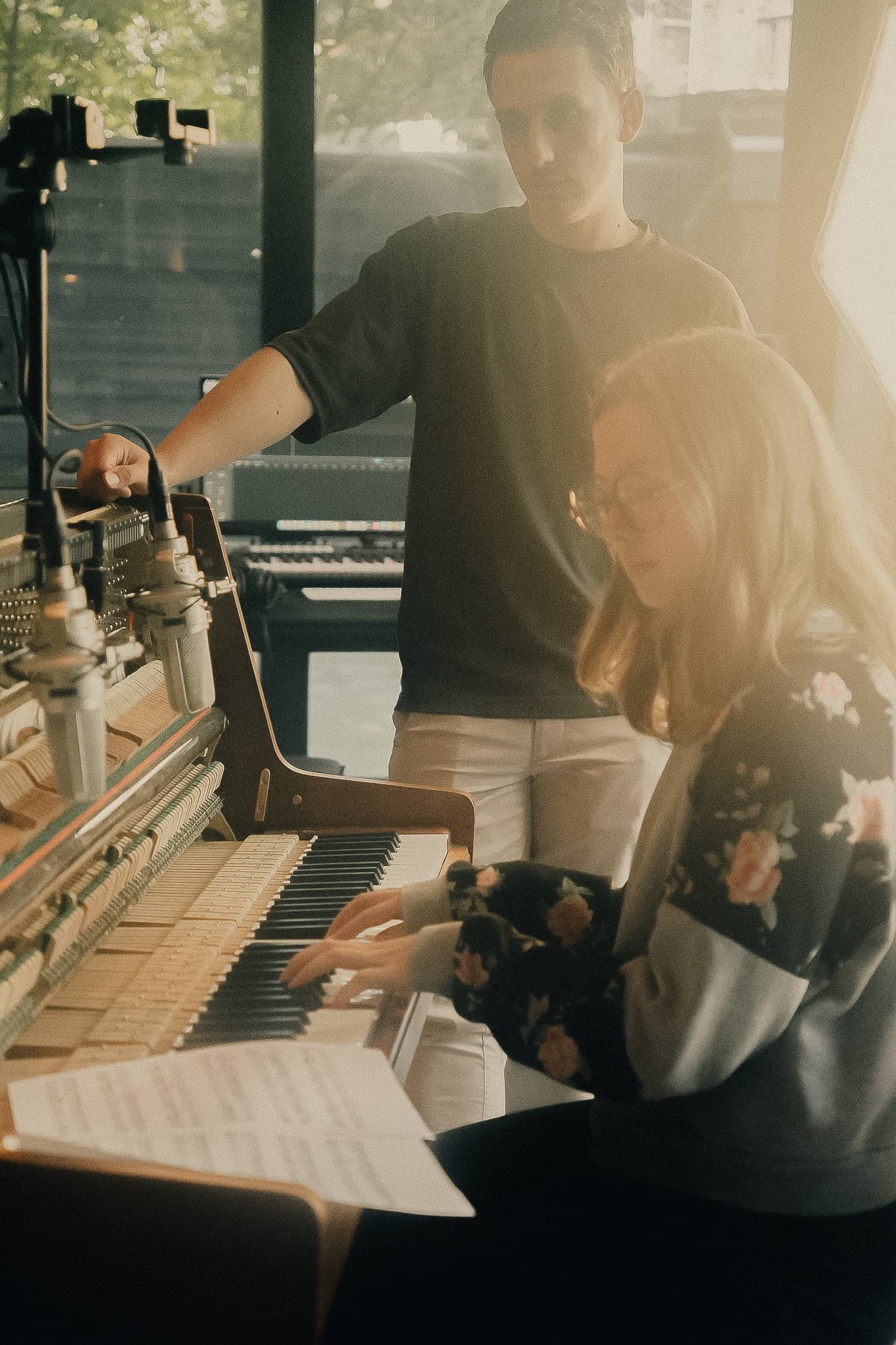 Ivo Adelaar standing at the opened, miked upright piano while an artist plays during a session at the Admiralengracht studio